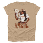 Tan t-shirt with a graphic of a woman in a cowboy hat holding a fan, with text 'WHERE THEM FANS AT' and 'BOOTS ON THE GROUND'.