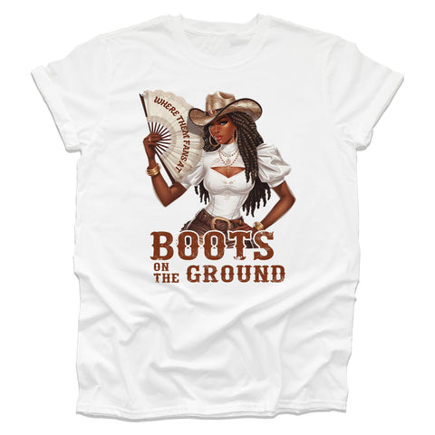 White t-shirt with a graphic of a woman in a cowboy hat holding a fan, with text 'WHERE THEM FANS AT' and 'BOOTS ON THE GROUND'.