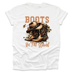White t-shirt with cowboy boots and hat graphic and 'Boots on the Ground' text