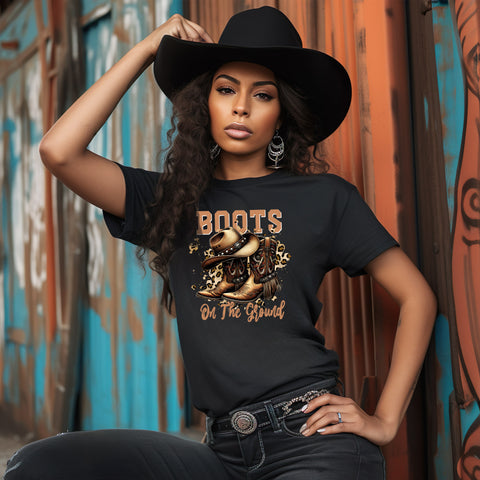 Woman wearing a black t-shirt with 'Boots on the Ground' graphic and text, posing against a colorful wall.